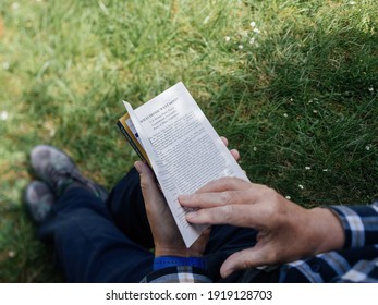 PARIS, France - May 3, 2020: Overhead View Of Curious Senior Male Reading The Book Rich Dad Poor Dad A Book By Robert Kiyosaki And Sharon Lechter