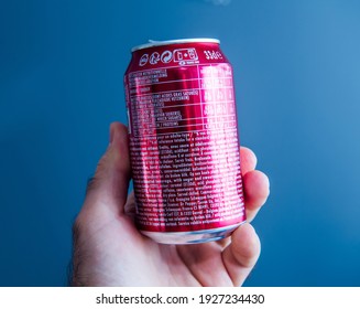 Paris, France - May 3, 2020: POV male hand holding top of aluminum can of Dr Pepper manufactured by Dr Pepper Snapple Group soft sweet drinks - isolated against gray background - reading reference