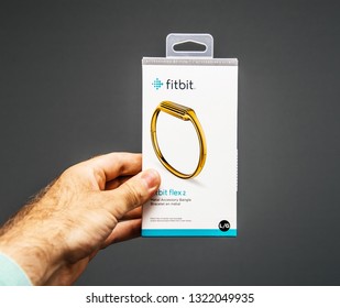 Paris, France - May 30, 2018: Male hand holding Fitbit wristband metal gold plated accessory bangled female sports tracker personal wearable device