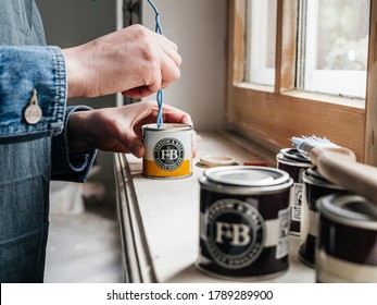 Paris, France - May 30, 2020: Close-up Side View Of Woman Mixing Paint Sample Pot Of Farrow And Ball Luxury British Paint Preparing To Paint The Wall And Window Frame