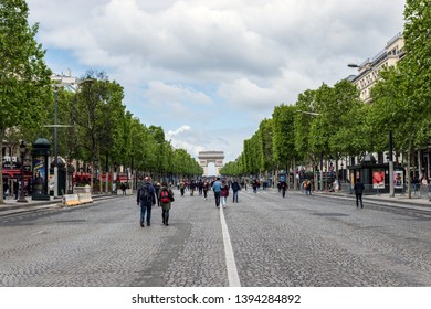 Paris, France - May 5, 2019: People Wandering On Champs Elysees Avenue With Arc De Triomphe In Background. The Avenue Is Closed To Car Traffic On First Sunday Of The Month.