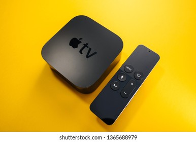 Paris, France - Nov 16, 2018: Side view from above at new black Apple TV 4K media streaming by Apple Computers  against yellow background - tilt-shift lens used