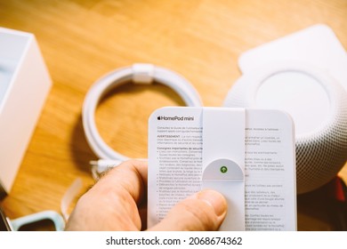 Paris, France - Nov 17, 2020: Reading Instruction Guide Of Latest Apple Computers HomePod Mini Smart Speaker Developed By The Computer Firm Reading The Instructions