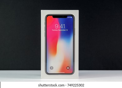 PARIS, FRANCE - NOV 3, 2017: Unboxing unpacking box of the latest Apple iPhone X 10 smartphone against black background