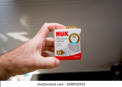 Paris, France - Nov 4, 2020: POV Male Hand Holding New NUK Nature Sense Silicone Top For Baby Bottle For Formula Milk