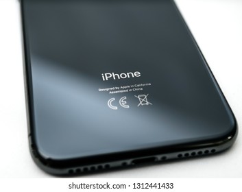 PARIS, FRANCE - NOV 5, 2017: Close-up of rear view of latest iPhone XS Telephone Smartphone with Designed by apple in California Made in China sign on the glass back tilt-shift lens focus