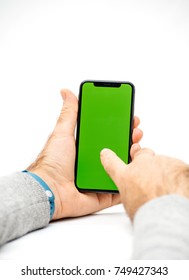 PARIS, FRANCE - NOV 5, 2017: New Apple IPhone X 10 Smartphone With Green Chroma Key Backdrop Against White Background In Male Hand