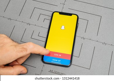 PARIS, FRANCE - NOV 9, 2017: Man POV Personal Perspective On The Latest IPhone X XS With Hand Pressing The Log In Button For Snapchat Social Network App