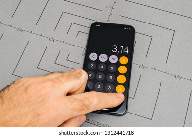 PARIS, FRANCE - NOV 9, 2017: Man POV Personal Perspective On The Latest IPhone X XS With Hand Pressing The Buttons Calculator App