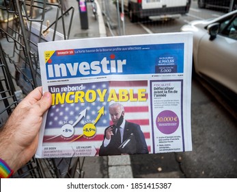 Paris, France - Nov 9, 2020: POV Male Hand Buying At Press Kiosk Newspaper Investir Investing With Nasdaq And CAC 40 Indexes Going Up After Biden Winning US Presidential Election Victory Against