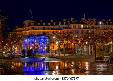 Paris, France - November 12, 2018: Colorful Night Urban Scene With Beautiful Illuminated Buildings And Blue Pavilion Reflected In Water After The Rain