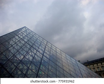 Paris, France - November 28th, 2017: Louvre Museum Glass Pyramid With Cloudy Background