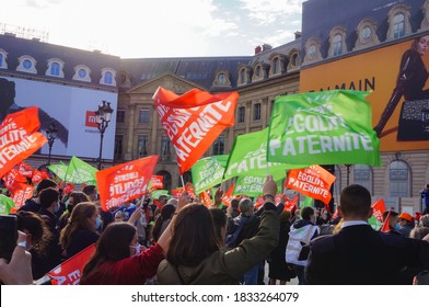 Paris, France - Oct. 10, 2020 - A multigenerational crowd of protesters cheerfully waving colorful flags, at a manifestation against fatherless MAP and surrogacy, in front of the Ministry of Justice