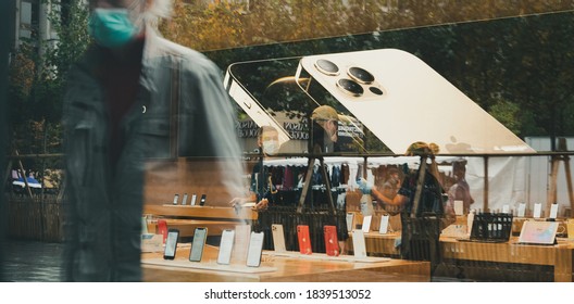 Paris, France - Oct 23, 2020: Senior man with mask reflected in Apple Store with the new iPhone 12 and iPhone 12 Pro on display during launch day. Latest 5G smartphones go on sale worldwide.