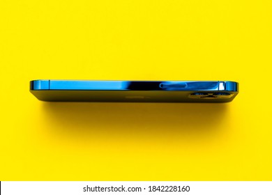 Paris, France - Oct 23, 2020: New Pacific Blue IPhone 12 Pro Max 5G Smartphone Model By Apple Computers Close-up Of Pacific Blue Mobile Phone Device Overhead View Isolated On Yellow