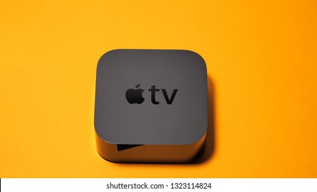 Paris, France - Oct 24 2018: Apple TV Unboxing Against Orange Background - Tv Streaming Device With Apple Logo On The Top