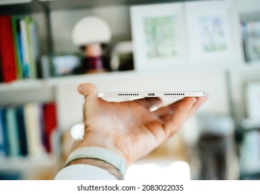 Paris, France - Oct 25, 2021: POV Male Hand Holding Latest Apple Computers IPad Mini Tablet Computer With Apple Pencil Against Bookshelves In Living Room