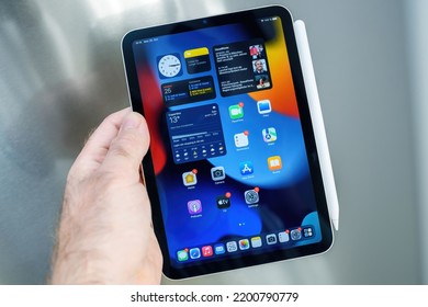 Paris, France - Oct 25, 2021: POV Male Hand Holding New Apple IPad Mini Pro Tablet With Pencil Charging On Steel Background - All Apps On The Home Screen