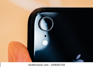 Paris France - Oct 26 2018: Man Hand Holding Latest IPhone XR Featuring An AR Camera Rear View With Single Lens Close-up Macro View