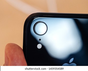 Paris France - Oct 26 2018: Man Hand Holding Latest IPhone XR Featuring An AR Camera And LED Flash Rear View With Single Lens