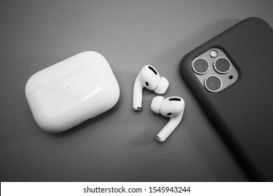 Paris, France - Oct 30, 2019: Charging case and the new iPhone 11 Pro next to New Apple Computers AirPods Pro headphones with Active Noise Cancellation for immersive sound