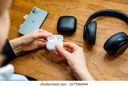 Paris, France - Oct 30, 2019: Overhead view of woman hands unboxing new Apple Computers AirPods Pro headphones with Active Noise Cancellation for immersive sound other Beats by Dr Dre headphones