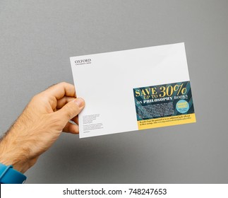PARIS, FRANCE - OCT 4, 2017: Male hand holding against grey background special offer discount flyer from Oxford University Press for philosophy books