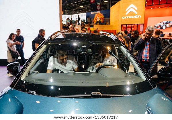 PARIS, FRANCE - OCT 4, 2018: Customers inside\
electric Citroen C5 Aicross suv admiring the new  technological car\
at exhibition Mondial Paris Motor\
Show