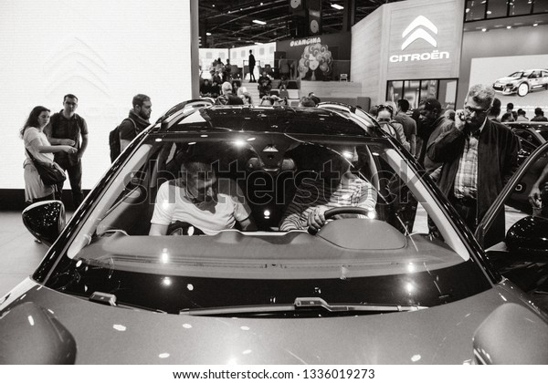 PARIS, FRANCE - OCT 4, 2018:\
Customers inside electric Citroen C5 Aicross suv admiring the new \
technological car at exhibition Mondial Paris Motor Show black and\
white