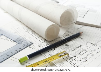 Paris, France - October 09, 2010: Set of drawing work equipment laid on home and kitchen layout plans with rolls of architect drawings
