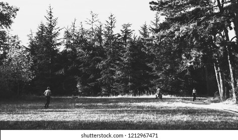 PARIS, FRANCE - OCTOBER 14, 2018: People Have Fun In Vincennes Forest Of Paris - Senior Man Making Fly Rc Plane;  Kids, Father And Grandfather Whirling; Woman Walking Dog. Black And White Photo.