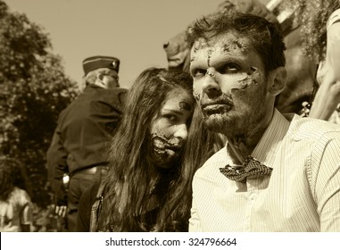 PARIS, FRANCE - OCTOBER 3, 2015: Zombie couple participating in Zombie parade at Place de la Republique and police force keeping order at background. Zombie Walk is an annual event in Paris.
