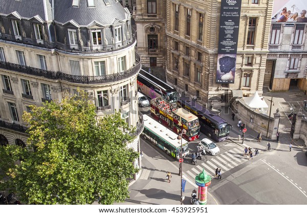 PARIS, FRANCE, on JULY 5,\
2016. A typical urban view from the survey platform of the Gallery\
department store Lafayette. Excursion buses have stopped near the\
crosswalk