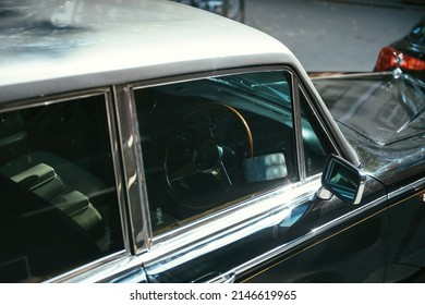 Paris, France - Sep 12, 2015: Lateral view of luxury Rolls-Royce Silver Wraith II with defocused city background - seen through the glass window of wooden luxury steering wheel