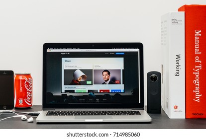 PARIS, FRANCE - SEP 13, 2017: Minimalist creative room table with Safari Browser open on MacPook Pro laptop showcasing Apple Computers website with latest Apple TV 4k with subscribe to itunes store 