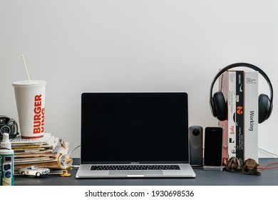 Paris, France - Sep 13, 2018: New Apple Computers MacBook Pro M1 M2 16 inch laptop in geek creative room environment with multiple design books, camera, smartphones and Dr Dre Beats Pro headphones