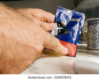 Paris, France - Sep 13, 2022: POV Male Hand Holding Pouch With Felix Wet Cat Food Beef Taste - Modern Kitchen Background Preparing To Feed The Pet Cat Animal