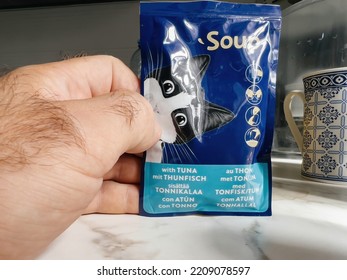 Paris, France - Sep 13, 2022: POV Male Hand Holding Pouch With Felix Wet Cat Food Tuna Taste - Modern Kitchen Background Preparing To Feed The Pet Cat Animal