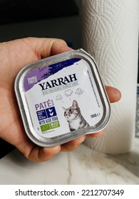 Paris, France - Sep 13, 2022: POV Male Hand Holding Pouch With Yarrah Wet Pate Cat Food Jelly With Chiken Meat And Aloe Vera - Modern Kitchen Background Preparing To Feed The Pet Cat Animal