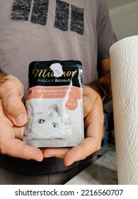 Paris, France - Sep 13, 2022: POV Male Hand Holding Pouch With Miamor Wet Cat Food With Tuna Fish Taste - Modern Kitchen Background Preparing To Feed The Pet Cat Animal