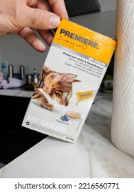 Paris, France - Sep 13, 2022: Male Hand Holding Pouch With Cream With Chciken And Blueberries Wet Cat Food Manufactured By Premiere - Modern Kitchen Background Preparing To Feed The Pet Cat Animal