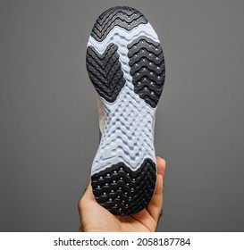 Paris, France - Sep 18, 2019: POV male hand holding isolated on gray background new Nike running shoe with Swoosh logotype