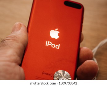 Paris, France - Sep 20, 2019: Man hand holding latest iPod music player product red color displayed in Apple Store as the device by Apple Computers goes on sale