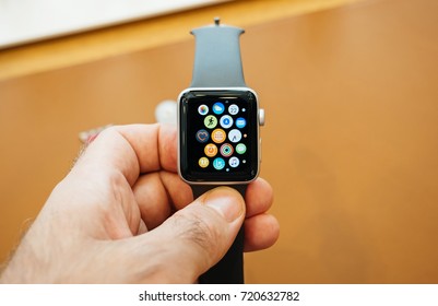 PARIS, FRANCE - SEP 22, 2017: New Apple Watch Series 3 goes on sale in Apple Store with male customer holding the face watch with home screen all apps 