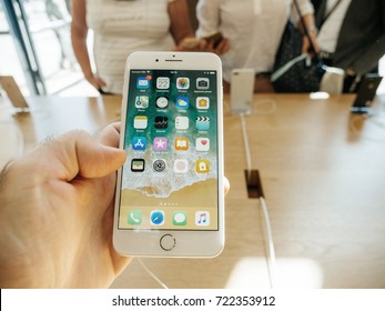 PARIS, FRANCE - SEP 22, 2017: New iPhone 8 and iPhone 8 Plus, as well the updated Apple Watch, Apple TV goes on sale today in Apple Store with man hand holding phone looking at the phone apps 