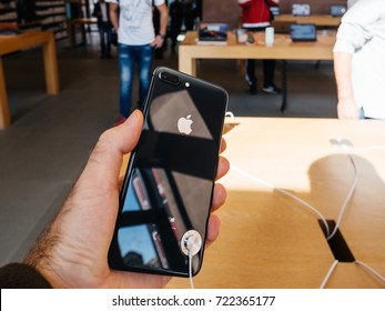 PARIS, FRANCE - SEP 22, 2017: New iPhone 8 and iPhone 8 Plus, as well the updated Apple Watch, Apple TV goes on sale today in Apple Store with customer holding the phone looking at the glass body 