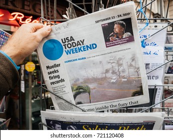 PARIS, FRANCE - SEP 23, 2017: Man Buying Latest Newspaper USA TODAY With Hurricane Maria Breaking News And Picture Of Damages Wind Sea Water 