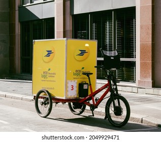 Paris, France - Sep 24, 2021: New Yellow La Poste Postal Bike With Electric Motor And Big Eco Logic Carbon Free Emission Bike Postage Parcel Delivery In City Center