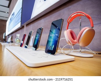 Paris, France - Sep 24, 2021: Row Of All Current Line Of Apple Computers IPhone Smartphone Telephones With Red Pink AirPods Max Headphones