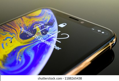 PARIS, FRANCE - SEP 25, 2018: Detail of  new iPhone 11 Xs and Xs Max Pro smartphone model by Apple Computers close-up of golden Apple iPhone mobile phone device reflective yellow technology background